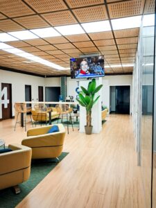 Área de espera moderna en una oficina de asesoría fiscal, contable y laboral para pymes y autónomos, con sillones cómodos, decoración natural y televisión informativa.